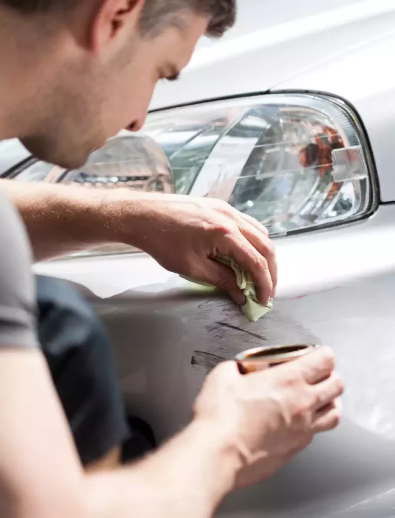 homme ave chiffon et pot répare carrosserie